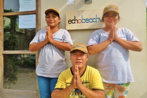 Tres personas frente a un edificio con un letrero que dice "echobeach".