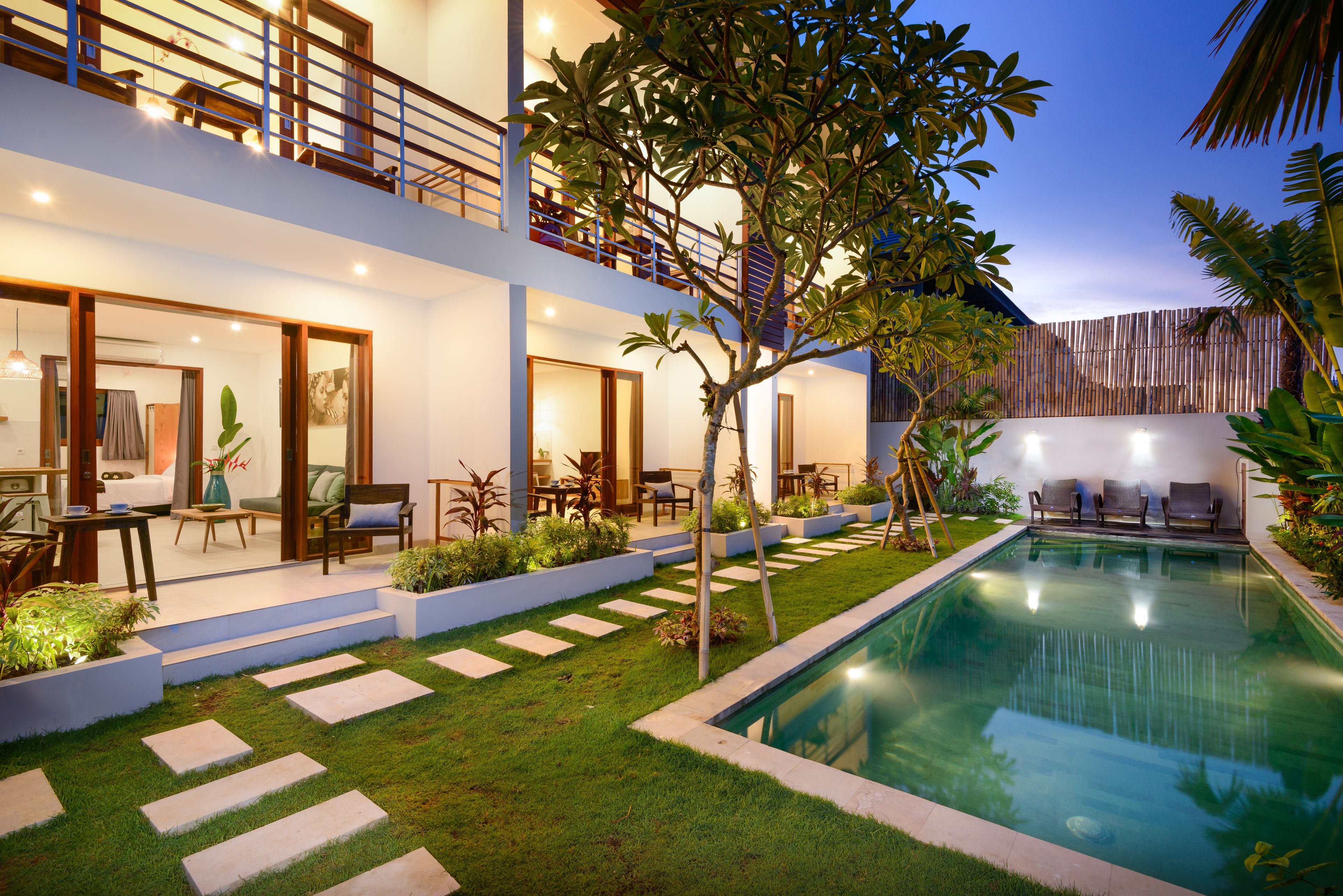 A modern two-story house with a swimming pool, outdoor seating, and a well-maintained garden.