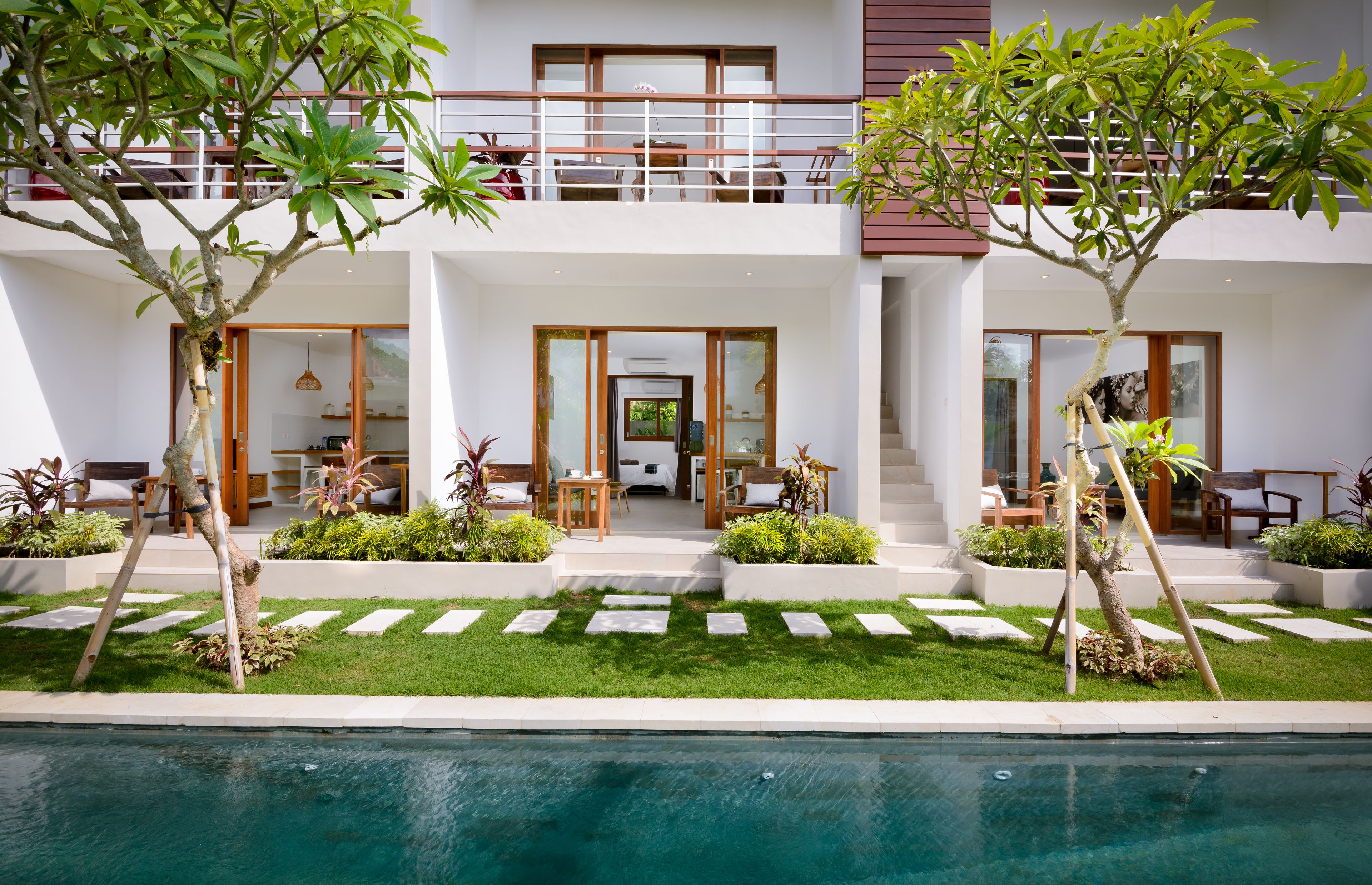 Un bâtiment moderne à deux étages doté d’une piscine, d’un espace extérieur aménagé et d’un jardin bien entretenu.