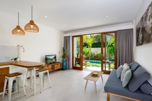 Apartemen Deluks, 1 kamar tidur, dapur, di pinggir kolam renang | Ruang keluarga | Televisi layar datar 32-inci dengan saluran TV kabel dan TV