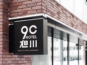 A hotel sign with the name "9C HOTEL" and "NINE C HOTEL ASAHIKAWA" in both English and Japanese. - 9 C Hotel Asahikawa (Asahikawa)