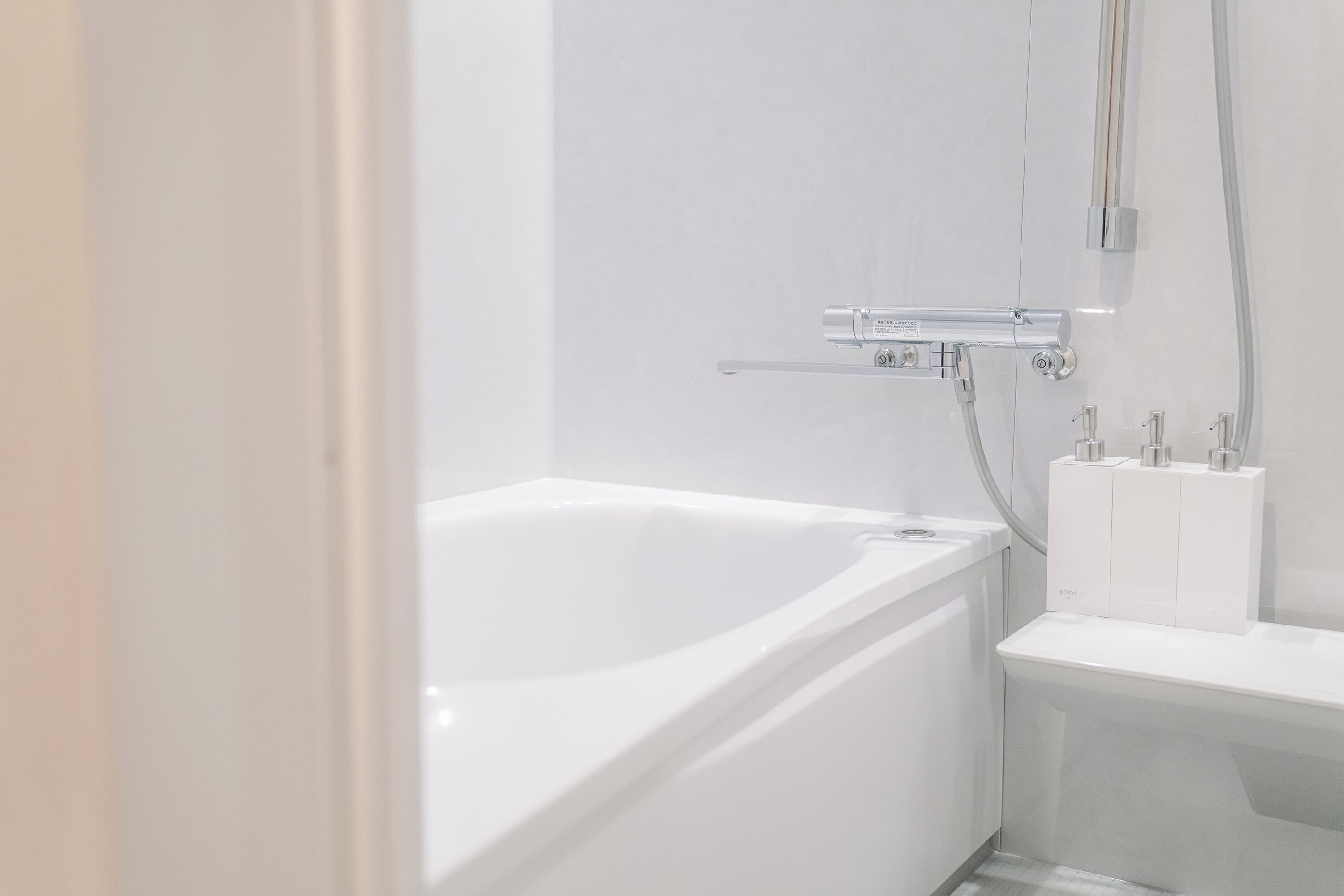 A modern bathroom with a white bathtub, a shower area, and a toilet.