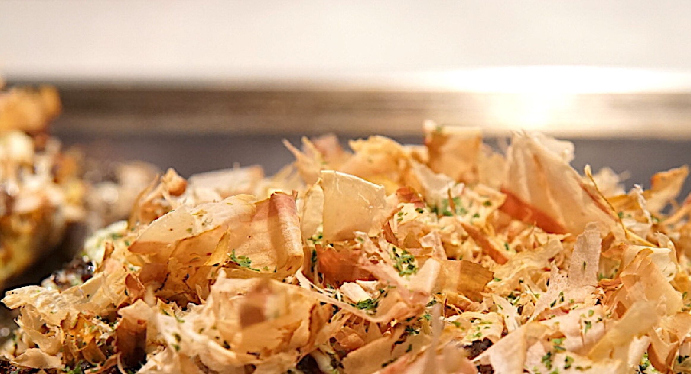 A close-up of shredded material, possibly food, with some green specks.