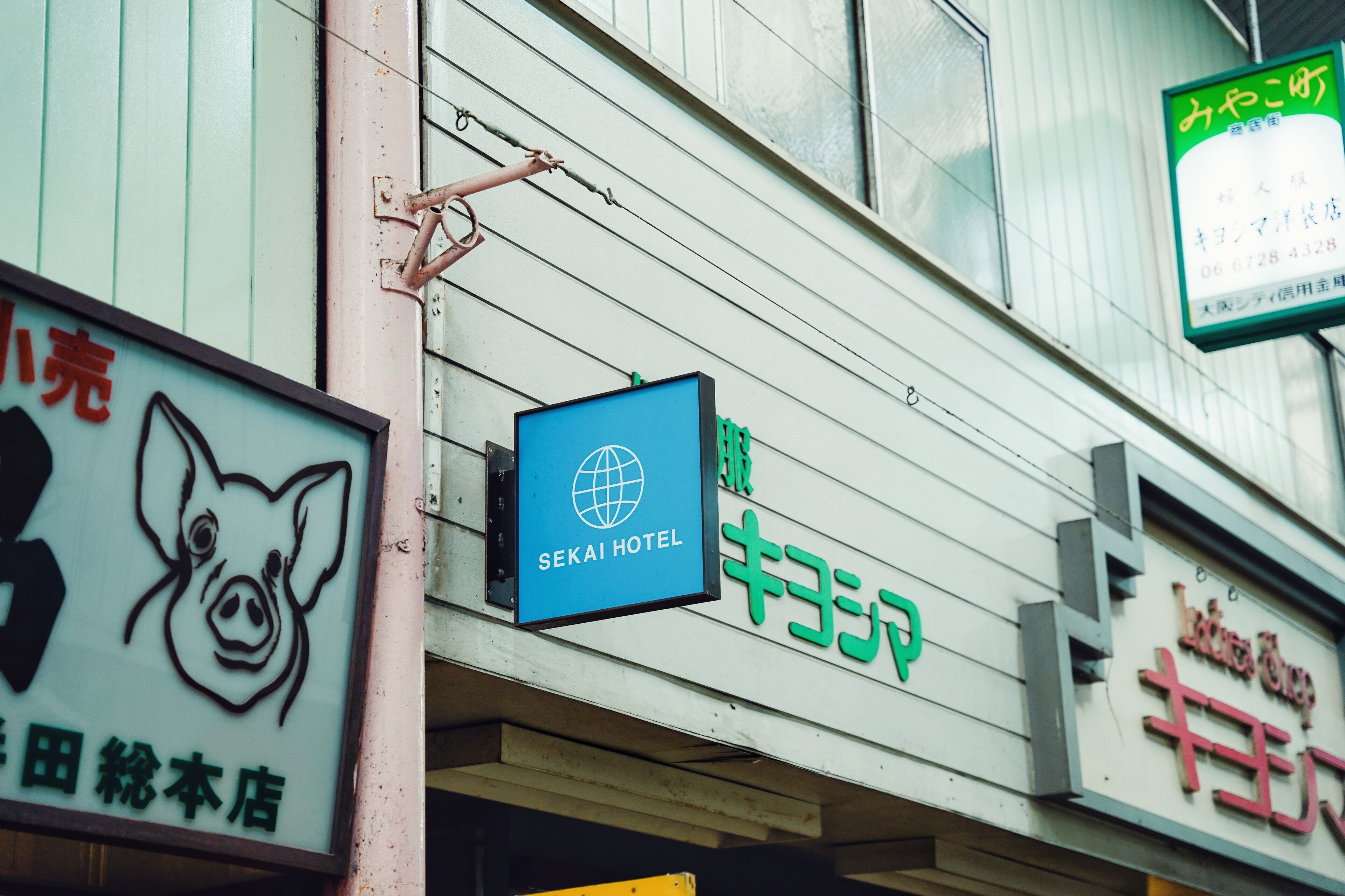 A hotel sign with a pig logo and the name "SEKAI HOTEL".