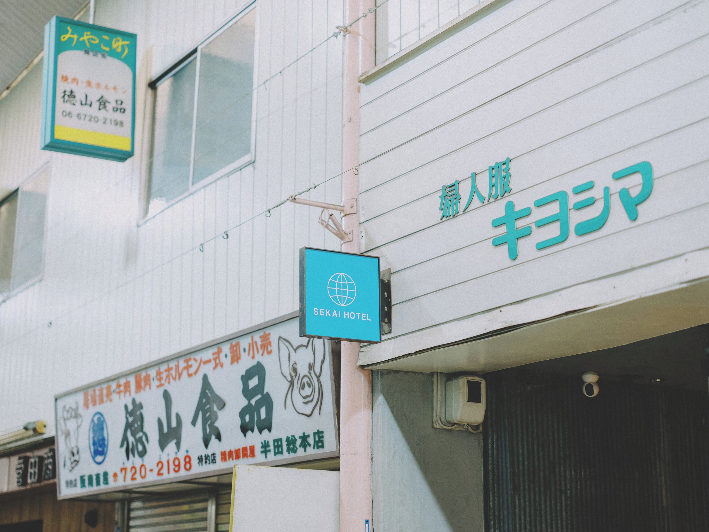 A building with multiple signs, including one for a hotel and another for a food product.