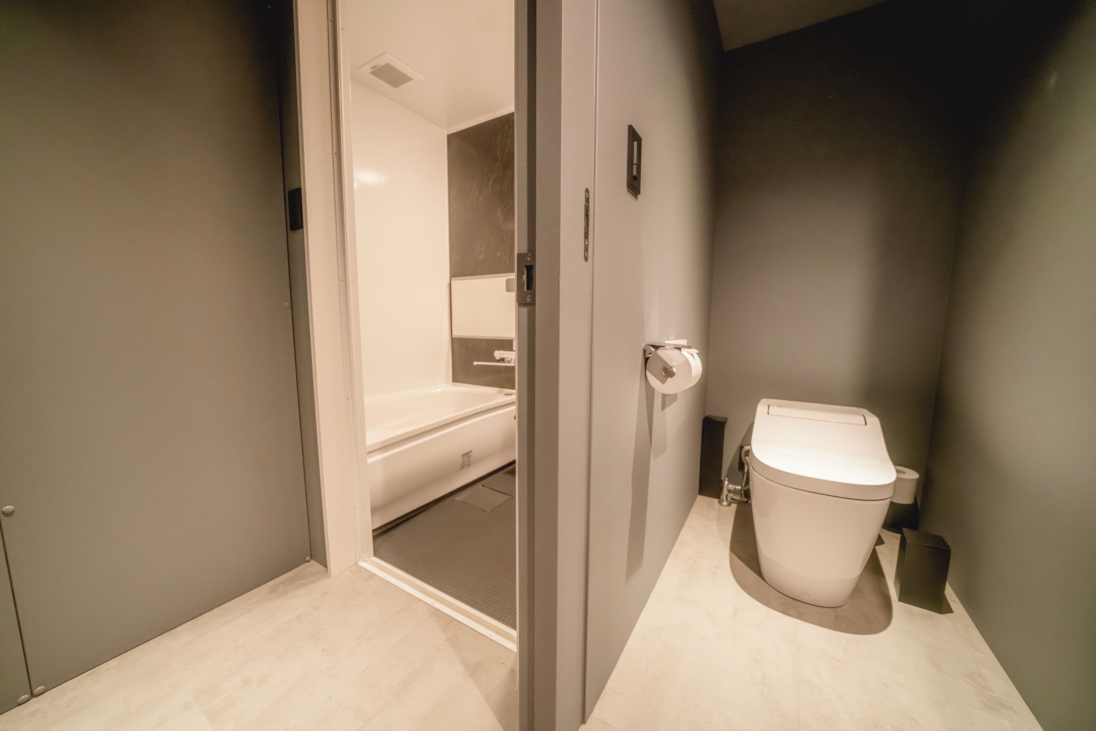 A modern bathroom with a toilet, a shower, and a bathtub.