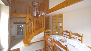 A spacious dining area with wooden furniture, a staircase, and a view of the kitchen. - A beautifully restored stone property overlooking the stunning Charente river.  (Luxé)