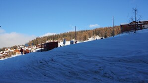 Een besneeuwde piste met gebouwen en bomen op de achtergrond.