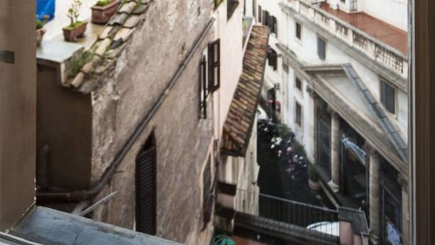 A view of a narrow street with buildings, including a church with a dome and a bell tower. - Penthouse with fantastic views of the monuments of Rome!
Free wi-fi (Roma)
