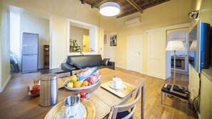 A spacious kitchen with a wooden ceiling, a dining table set with plates, a kettle, and a fruit bowl. - Penthouse with fantastic views of the monuments of Rome!
Free wi-fi (Roma)