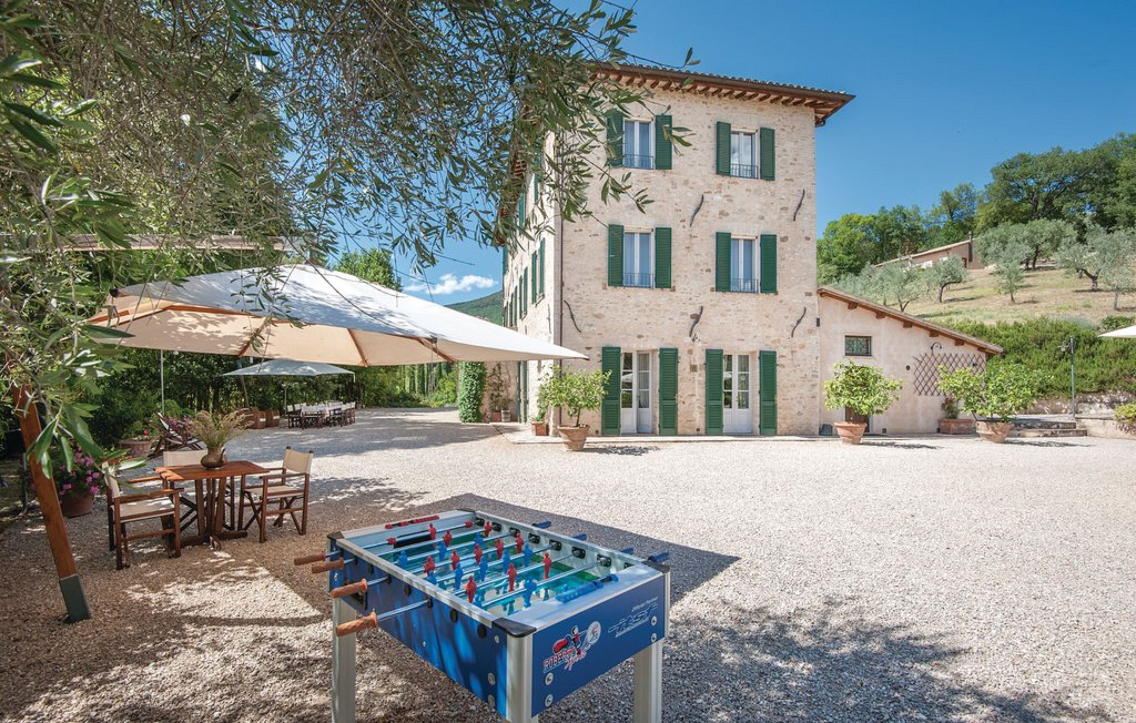 A building with a courtyard, outdoor seating, and a foosball table.