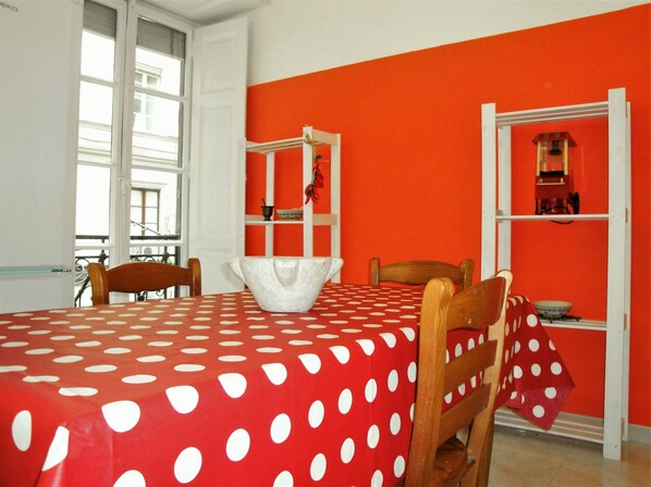 A dining area with a red tablecloth, wooden chairs, and a white bowl on the table. - Garibaldi Holiday House (26)
