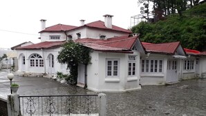 Un bâtiment blanc avec des toits rouges et une cour pavée.
