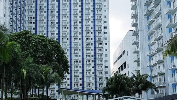 Une piscine entourée de grands immeubles d’habitation dotés de balcons.