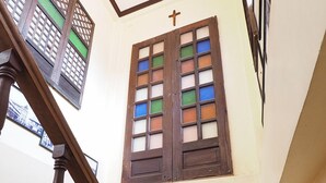 A staircase with wooden balusters and a fire extinguisher on the wall. - Balay Travel Lodge (Paoay)