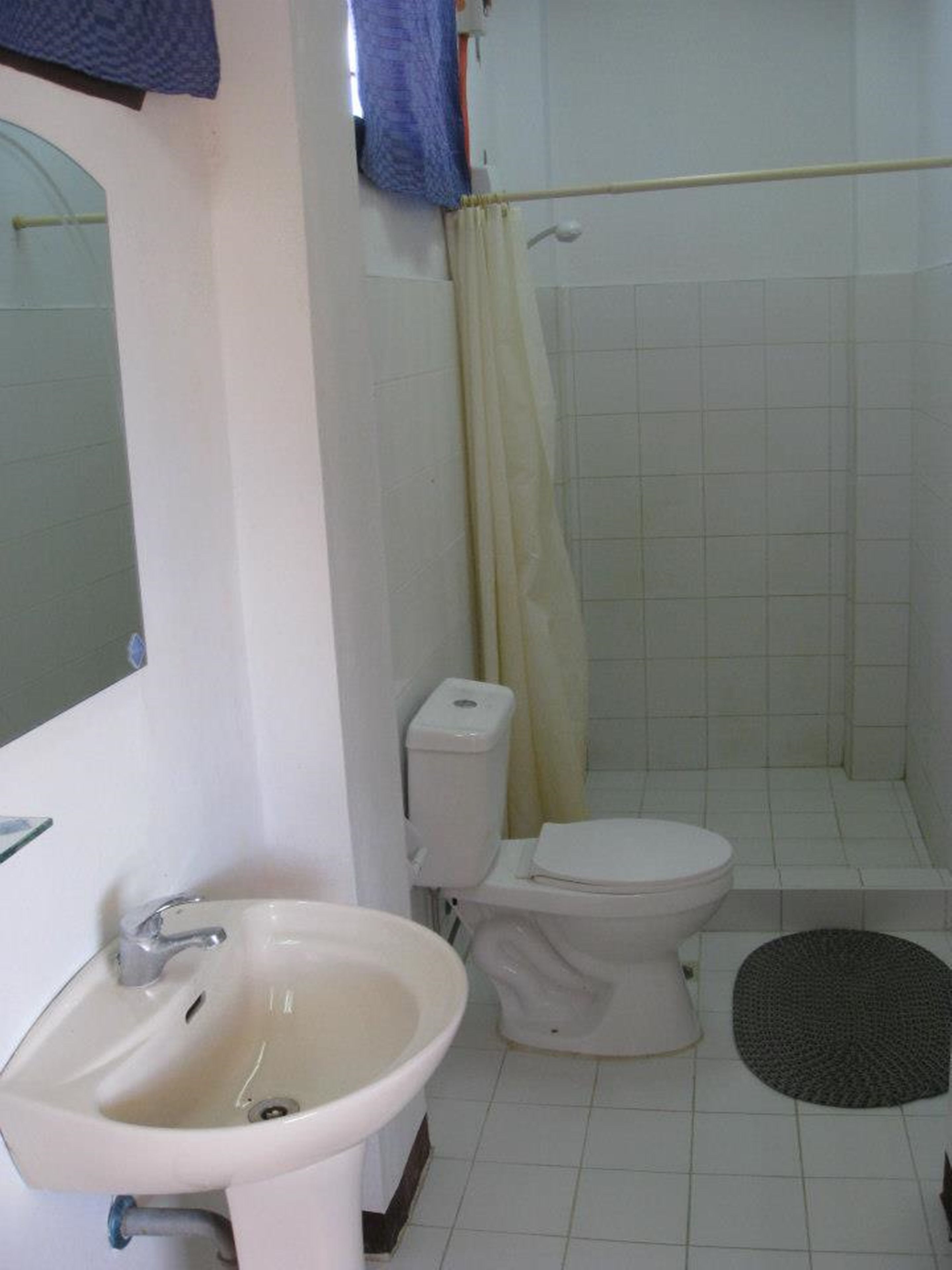 A bathroom with a sink, toilet, and shower area.