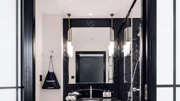 A modern bathroom with a black vanity, a large mirror, and a shower.