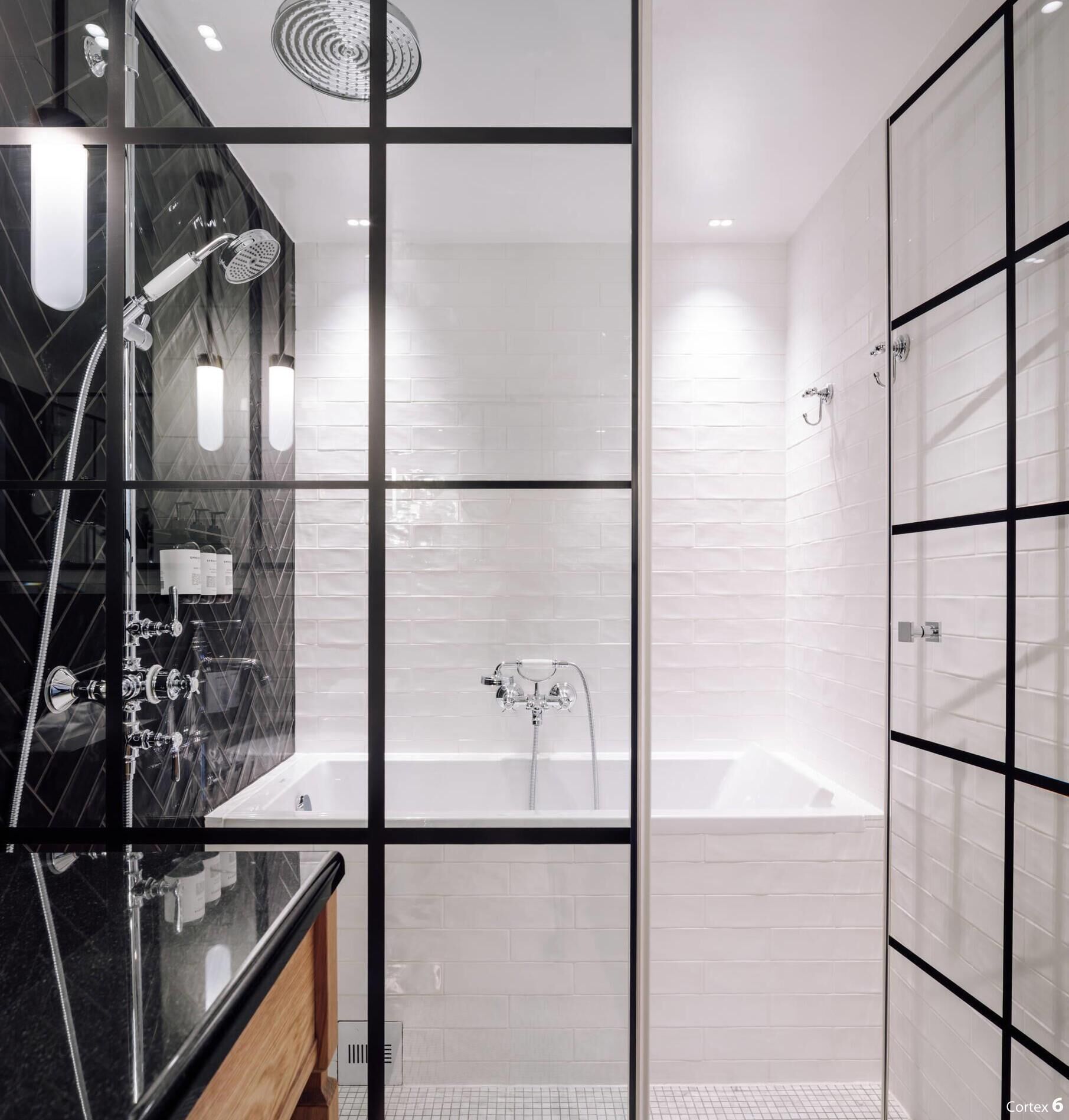 A modern bathroom with a glass shower enclosure, a separate bathtub, and a vanity with a mirror.