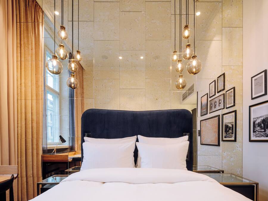 Habitación de hotel con una cama grande, un escritorio y una ventana con cortinas.