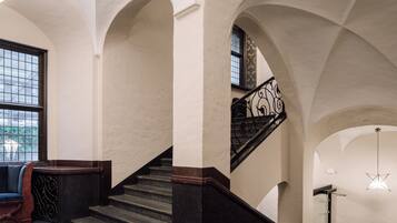 A grand staircase with dark steps and ornate railings, leading to an upper level.