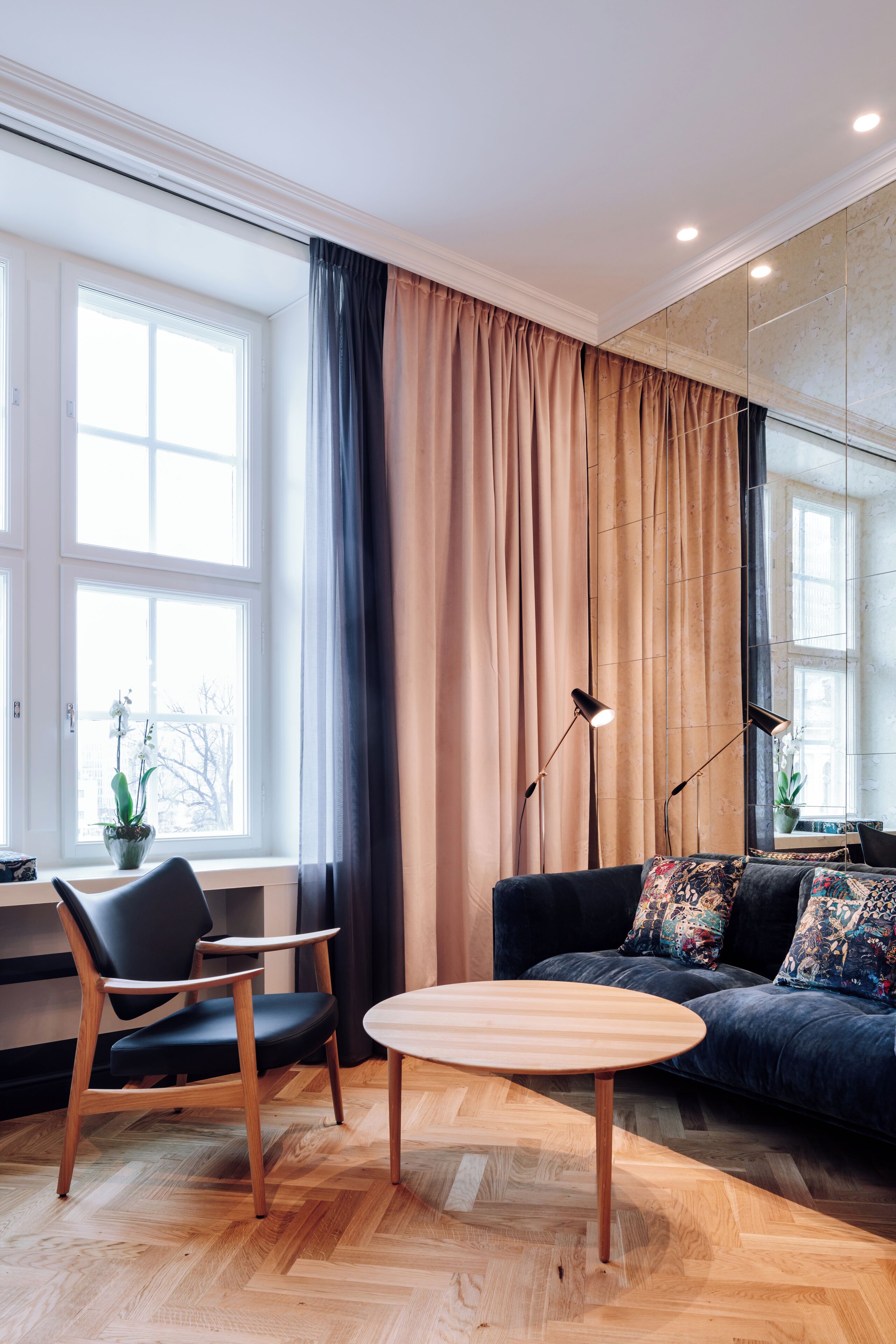 A modern living room with a sofa, a chair, a round table, and a floor lamp.