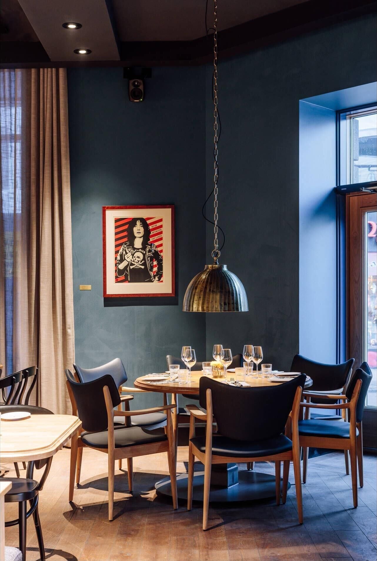 Un espace repas comprenant une table ronde, des chaises et un luminaire suspendu.