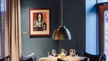 A dining area with a round table, chairs, and a hanging light fixture.