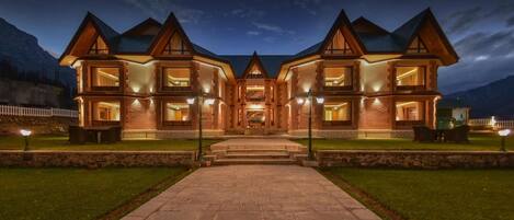 Vista frontal de la propiedad por la tarde o noche