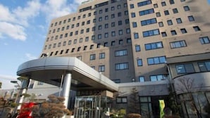 A multi-story hotel with a modern design, featuring a prominent entrance with a curved roof structure. - Kur and Hotel Shinshu (Shiojiri)