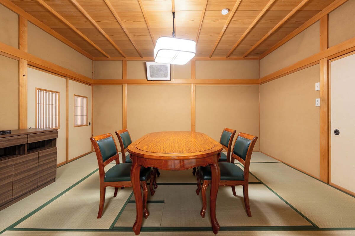 Een traditionele Japanse kamer met tatami vloeren, een houten tafel en stoelen.