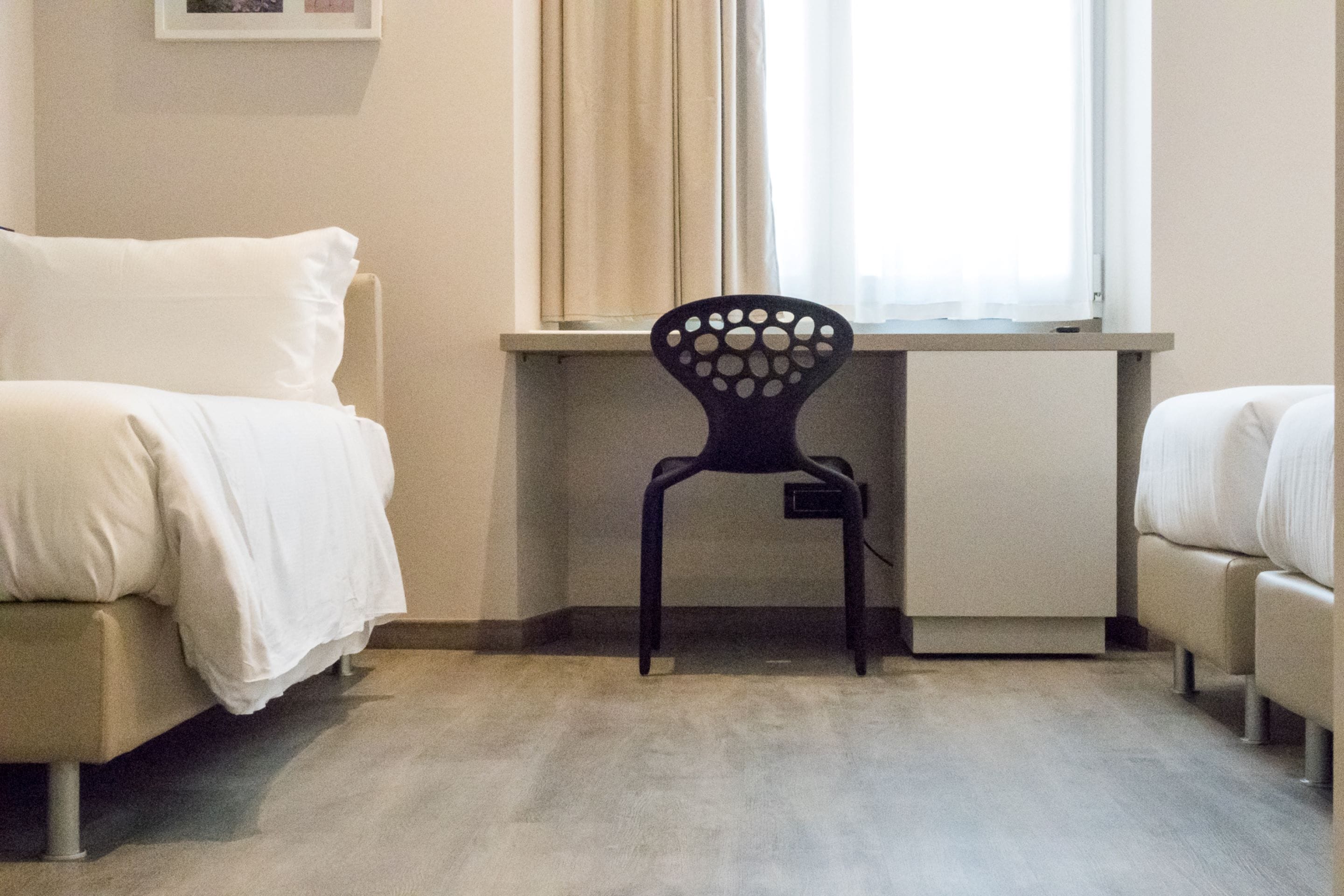 A room with a bed, a desk, and a chair.