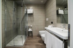 Un bagno moderno con doccia vetrata, lavandino bianco e water.