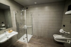Un bagno moderno con doccia vetro, lavabo e bidet.