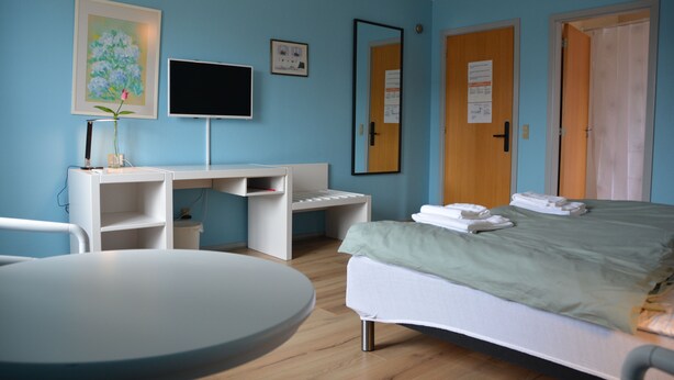 A hotel room with a bed, a desk, a chair, a TV, and a small table. - Abild Hotel (Tonder)