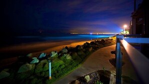 Une vue nocturne de la côte, avec un sentier menant à un bâtiment.