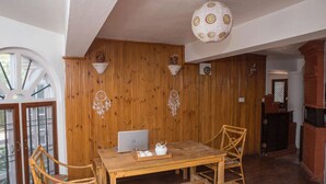 Interior de madera con una mesa, sillas, un ordenador portátil y decoración mural.