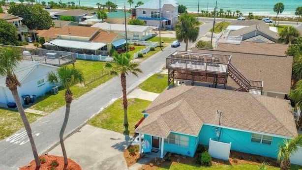 A residential area with houses, a street, and a view of the ocean.