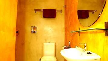 A bathroom with a toilet, sink, and mirror.