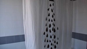 A bathroom with a shower curtain featuring a rain pattern. - Hostal La Tablada (Navaleno)