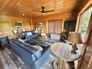 Ein Ferienhaus-Innenraum mit einer Couch, einem Couchtisch und einem Essbereich.