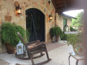 A stone building with a black door, two lanterns, and potted plants. - Quiet country setting, 15 min to Waco, 20 min to Baylor University (Crawford)
