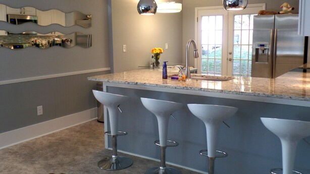 A modern kitchen with a central island, bar stools, stainless steel appliances, and pendant lighting. - Recently renovated, new front porch and walk-able to the town of Black Mountain  (Black Mountain)