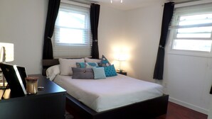 A bedroom with a bed, bedside tables, a desk, and a lamp. - Recently renovated, new front porch and walk-able to the town of Black Mountain  (Black Mountain)