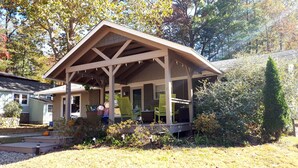 A wooden gazebo with a sloped roof, surrounded by a garden with various plants and a small pumpkin. - Recently renovated, new front porch and walk-able to the town of Black Mountain  (Black Mountain)