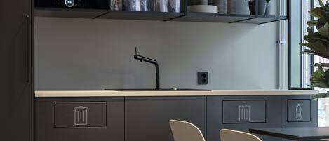 A modern kitchen with a Bosch microwave, a sink, and two chairs.
