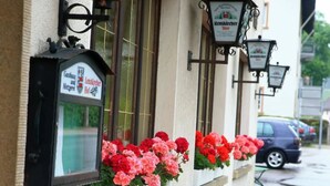 A building with a sign for 'Lenzkircher Hof' and flower boxes with red and pink flowers. - Lenzkircher Hof (Lenzkirch)
