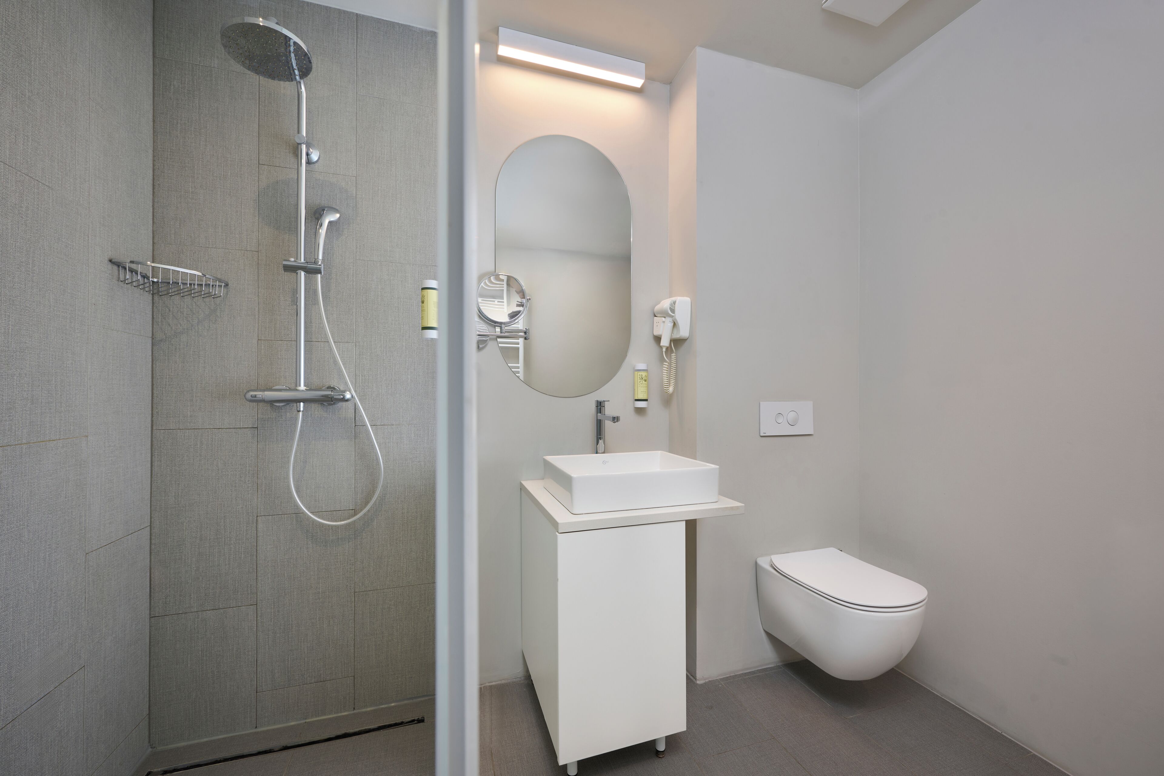 A modern bathroom with a shower, toilet, and vanity.