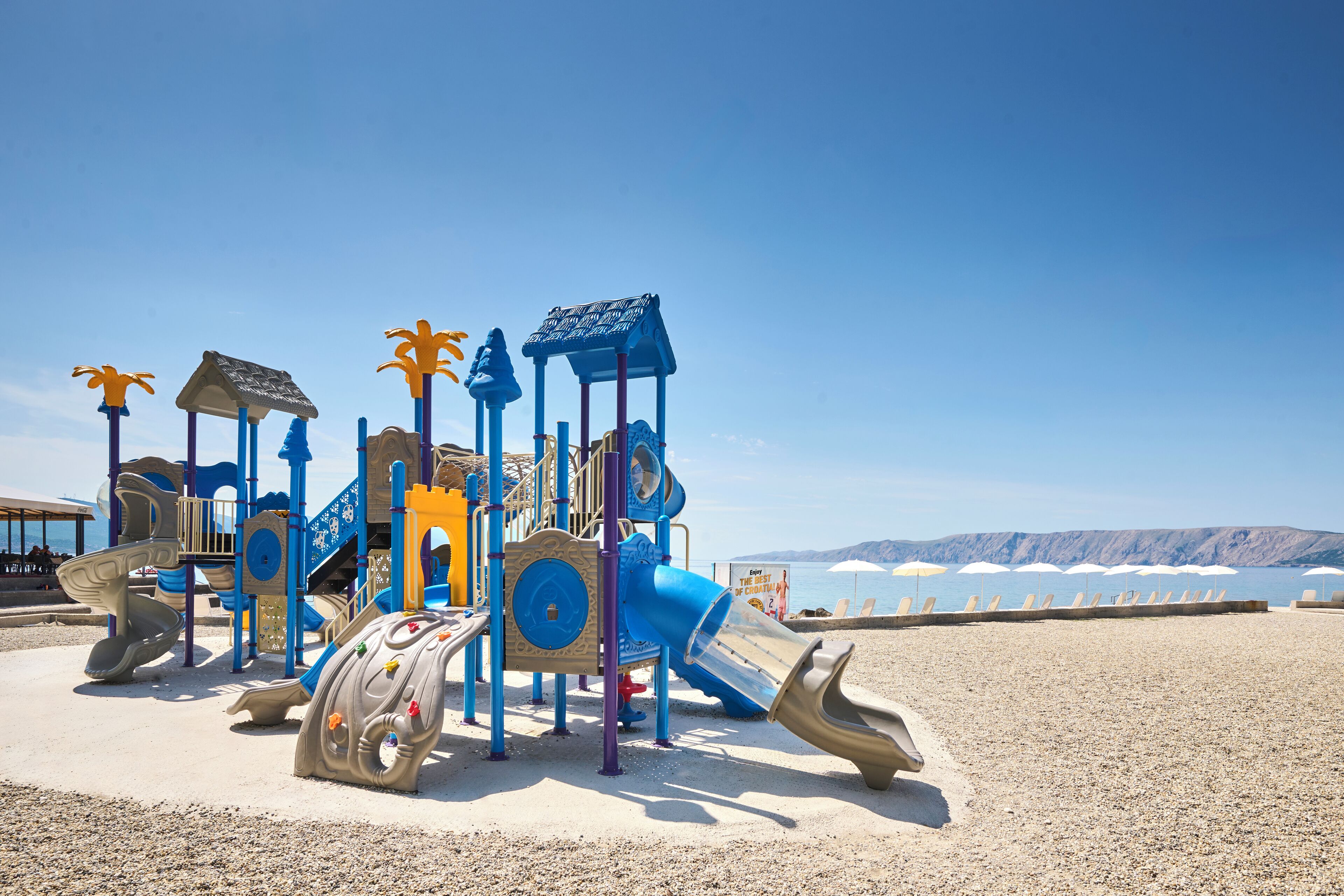 A beach playground with slides and climbing structures.
