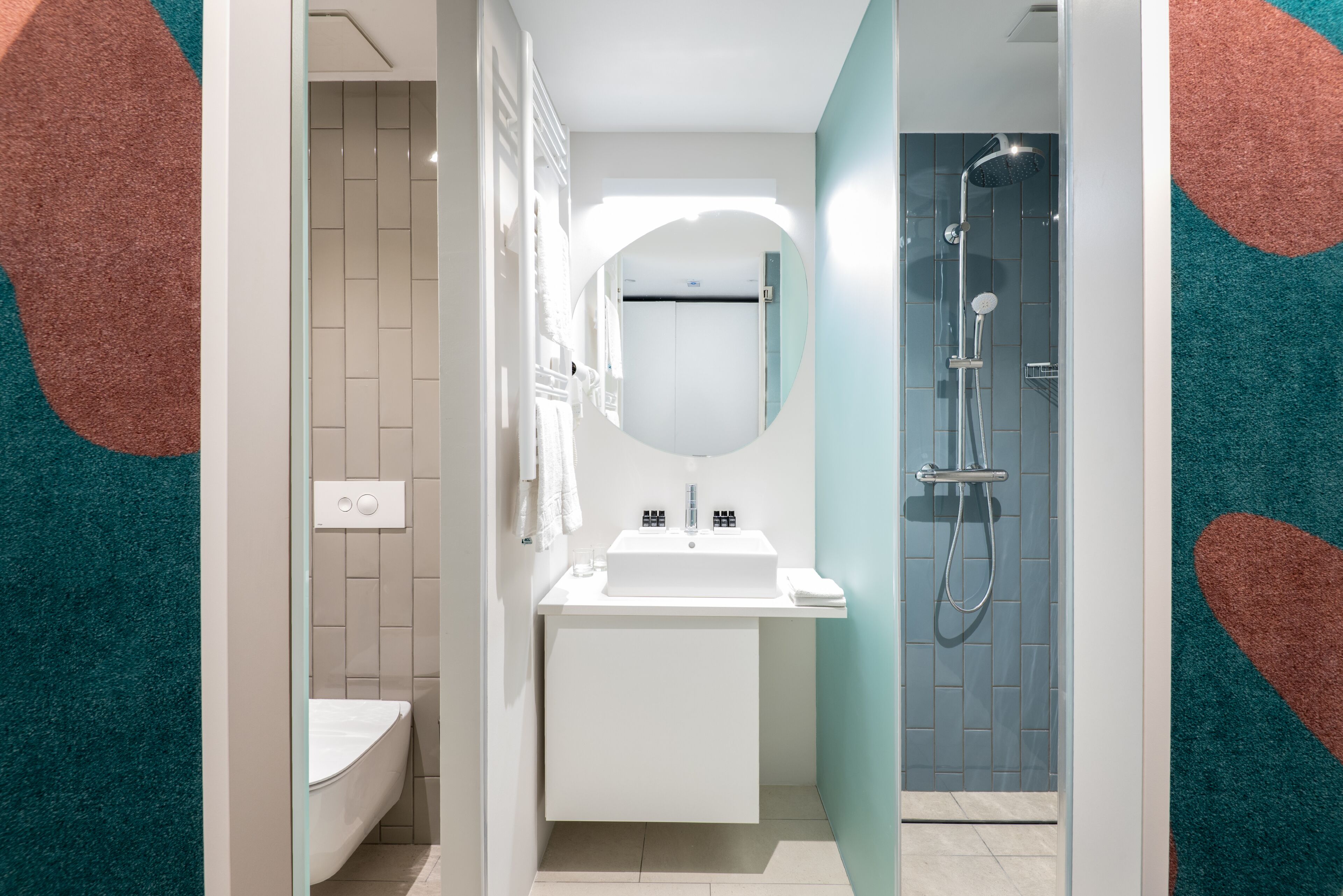 A modern bathroom with a white sink, mirror, and shower.
