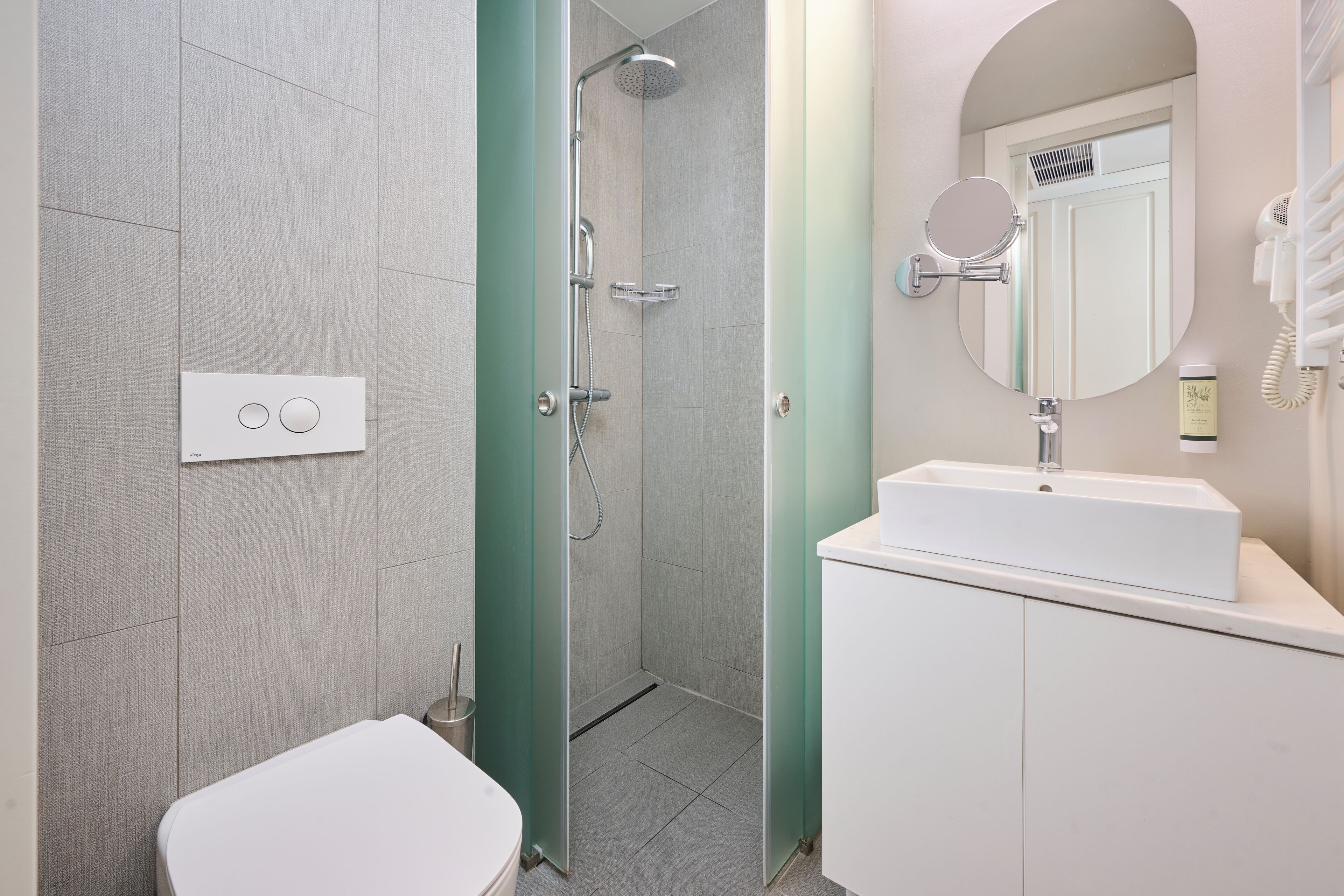 A modern bathroom with a shower, toilet, and sink.